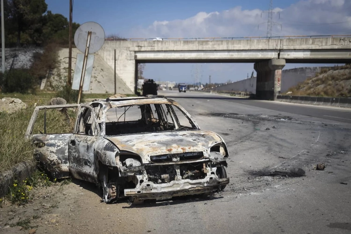 Сожженный в ходе столкновений в Латакии автомобиль. Фото: AP